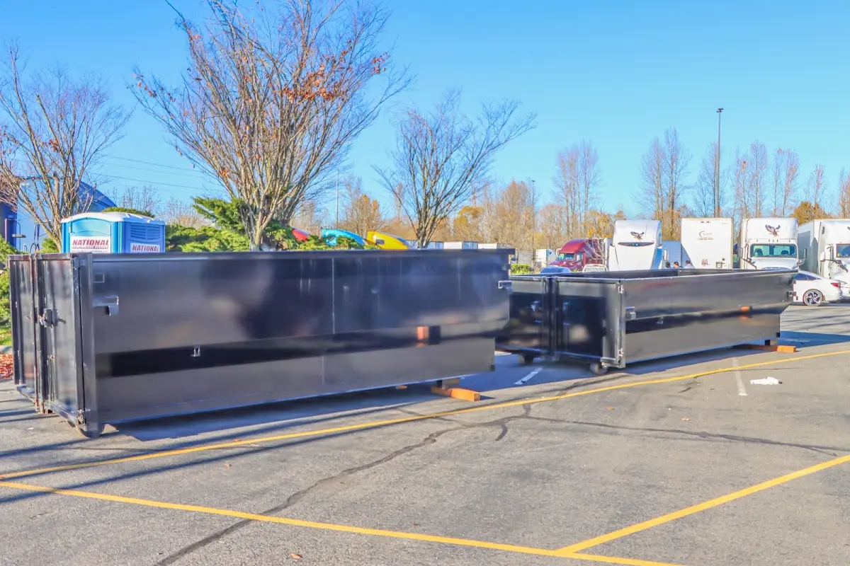 Professional dumpster rental service with roll-off container on residential driveway in Hudson Falls